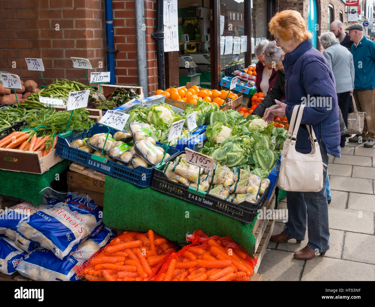 Agli acquirenti di acquistare frutta e verdura da un display esterno a un fruttivendolo shop in Northallerton North Yorkshire England Regno Unito 2017 prezzi mostrati Foto Stock