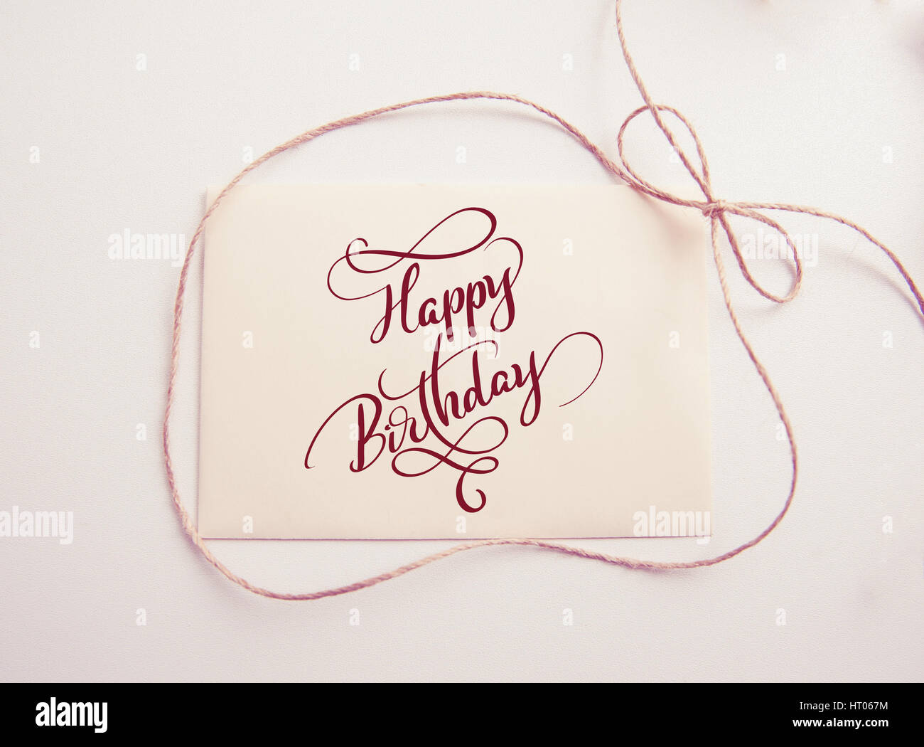 Foglio di carta con la prua e testo buon compleanno. Calligraphy lettering. Greating card Foto Stock