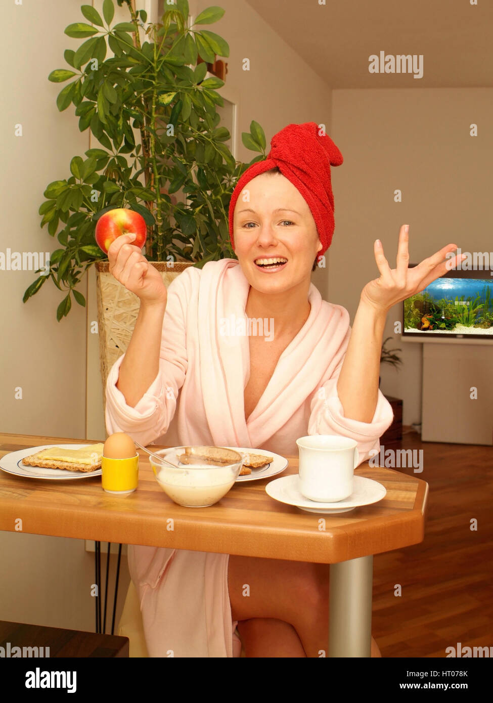 Junge Frau im Morgenmantel beim gesunden Fruehstueck - giovane donna alla sostanziosa colazione Foto Stock