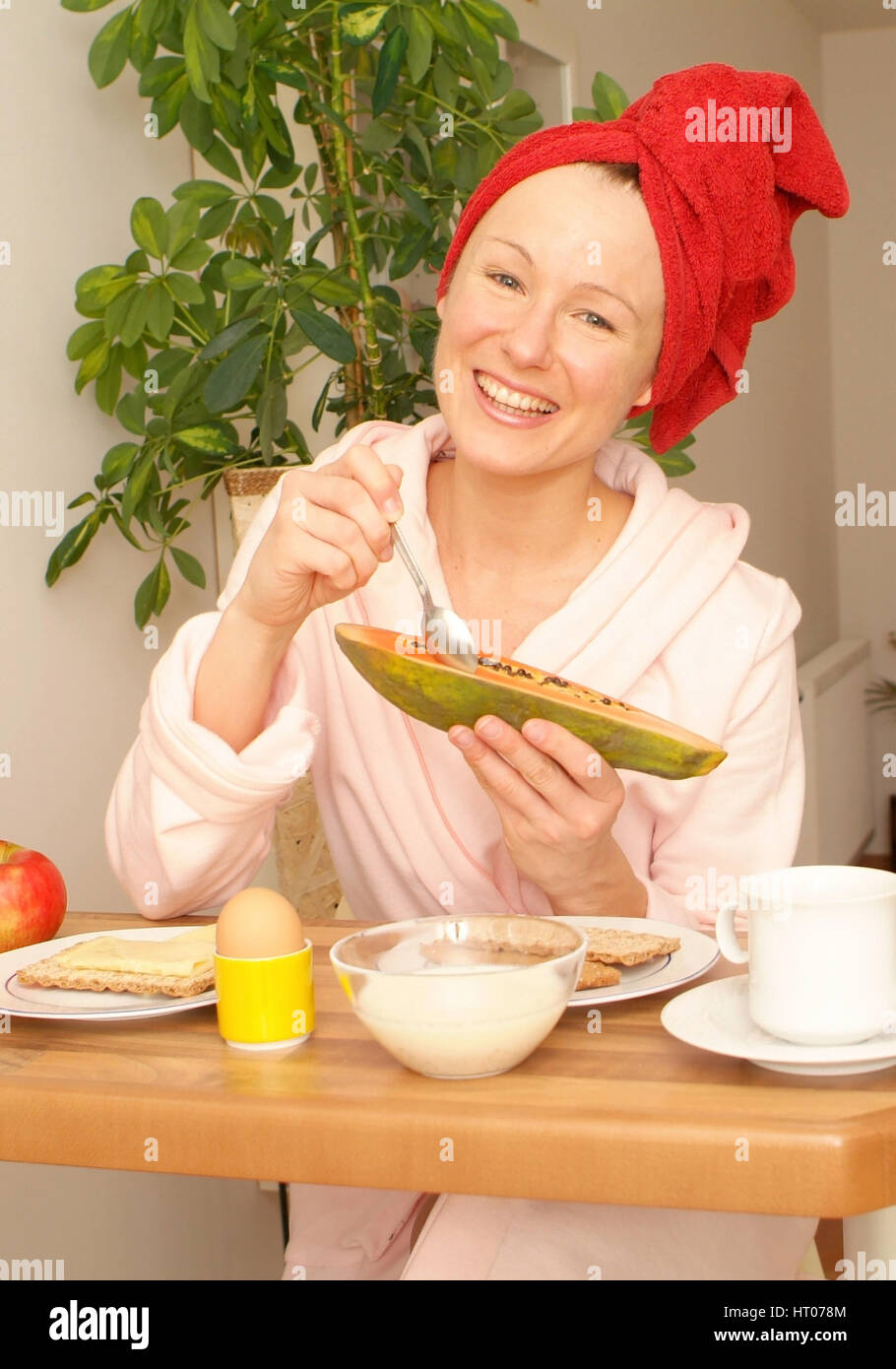 Junge Frau im Morgenmantel beim gesunden Fruehstueck - giovane donna in accappatoio a sostanziale prima colazione Foto Stock