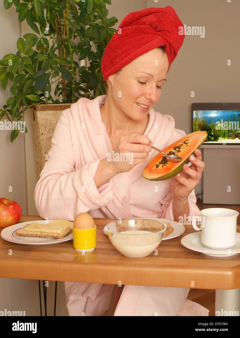 Junge Frau im Morgenmantel beim gesunden Fruehstueck - giovane donna alla sostanziosa colazione Foto Stock