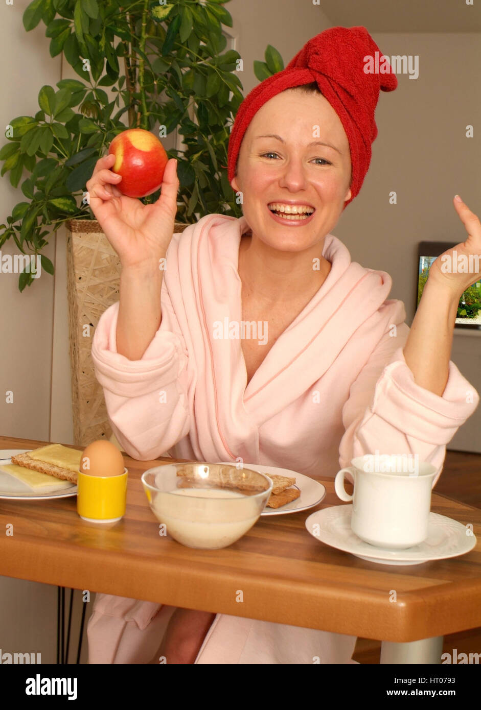 Junge Frau im Morgenmantel beim gesunden Fruehstueck - giovane donna alla sostanziosa colazione Foto Stock