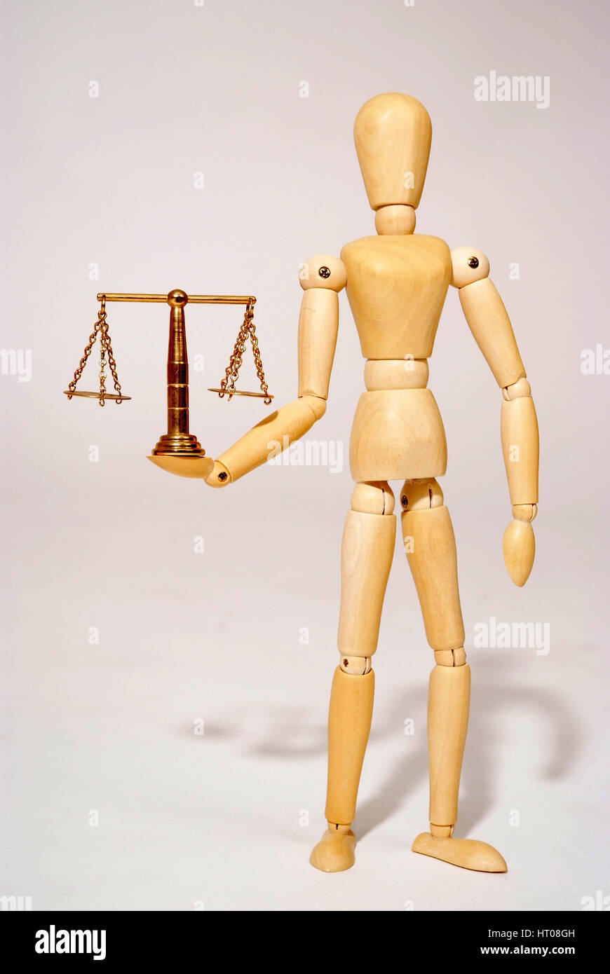 Holzpuppe mit Messingwaage, Symbolbild Gerechtigkeit - bambola articolata con scala Foto Stock