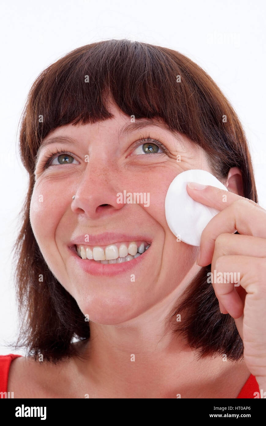 Junge Frau reinigt ihr Gesicht Mit einem Wattepad - cura del viso Foto Stock