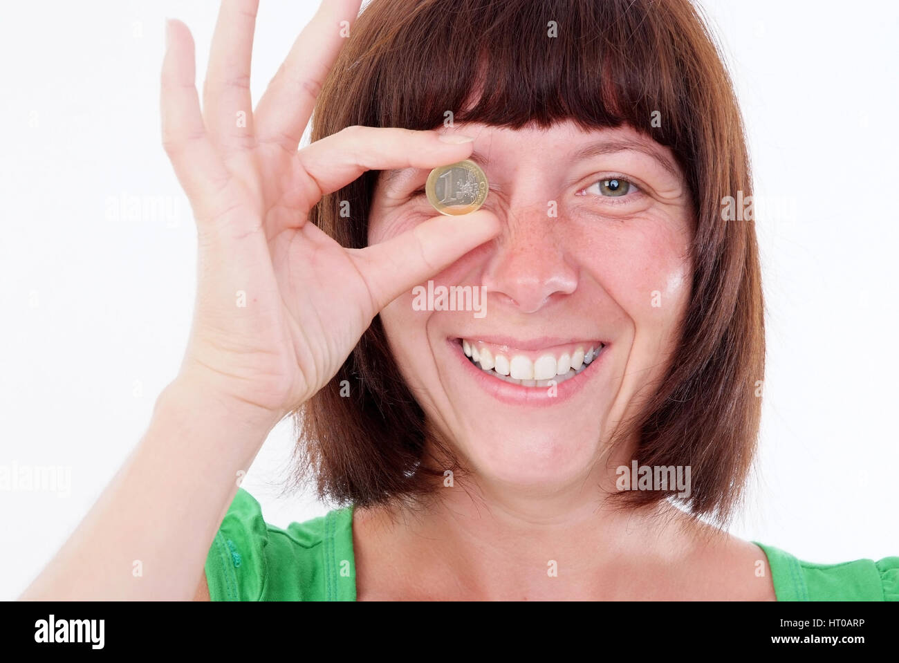 Frau mit Euromuenze vor dem Auge - donna con monete in euro Foto Stock