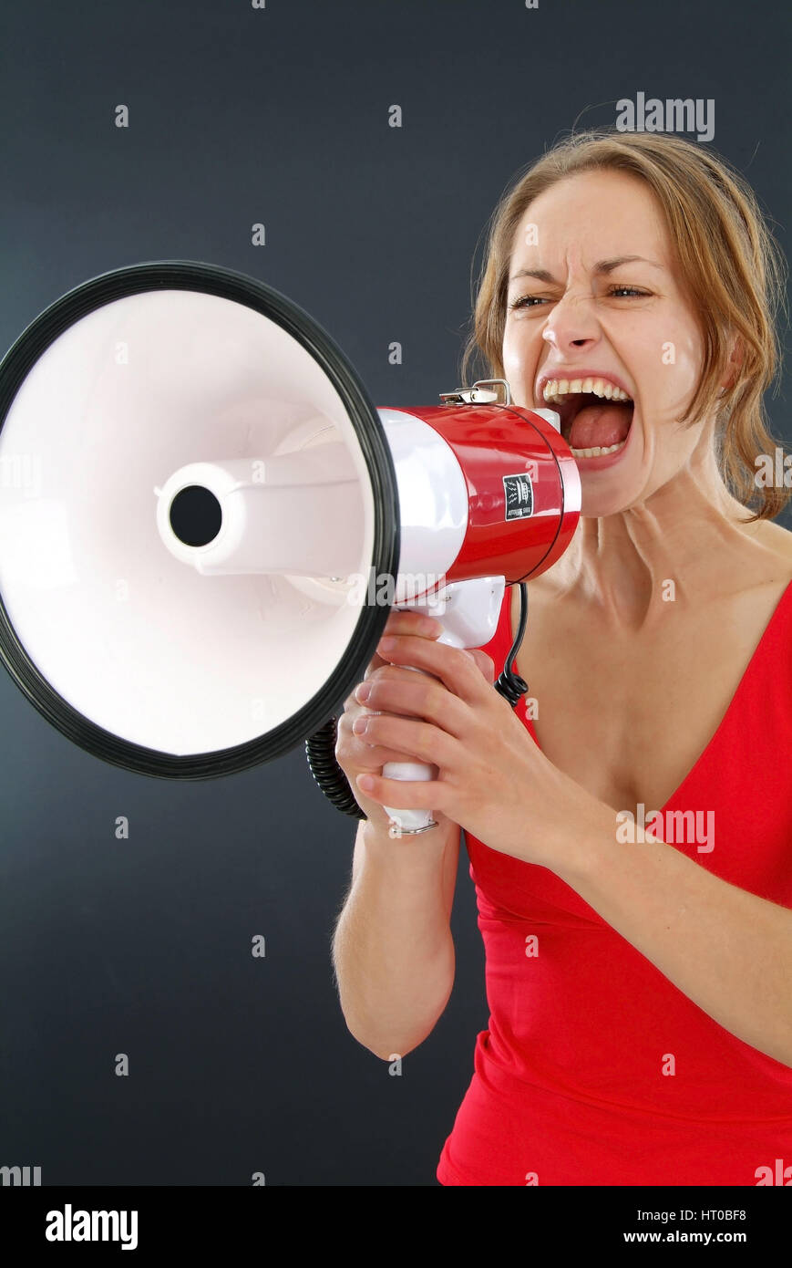 Junge Frau schreit in ein Megaphon - giovane donna urlando in un megafono Foto Stock