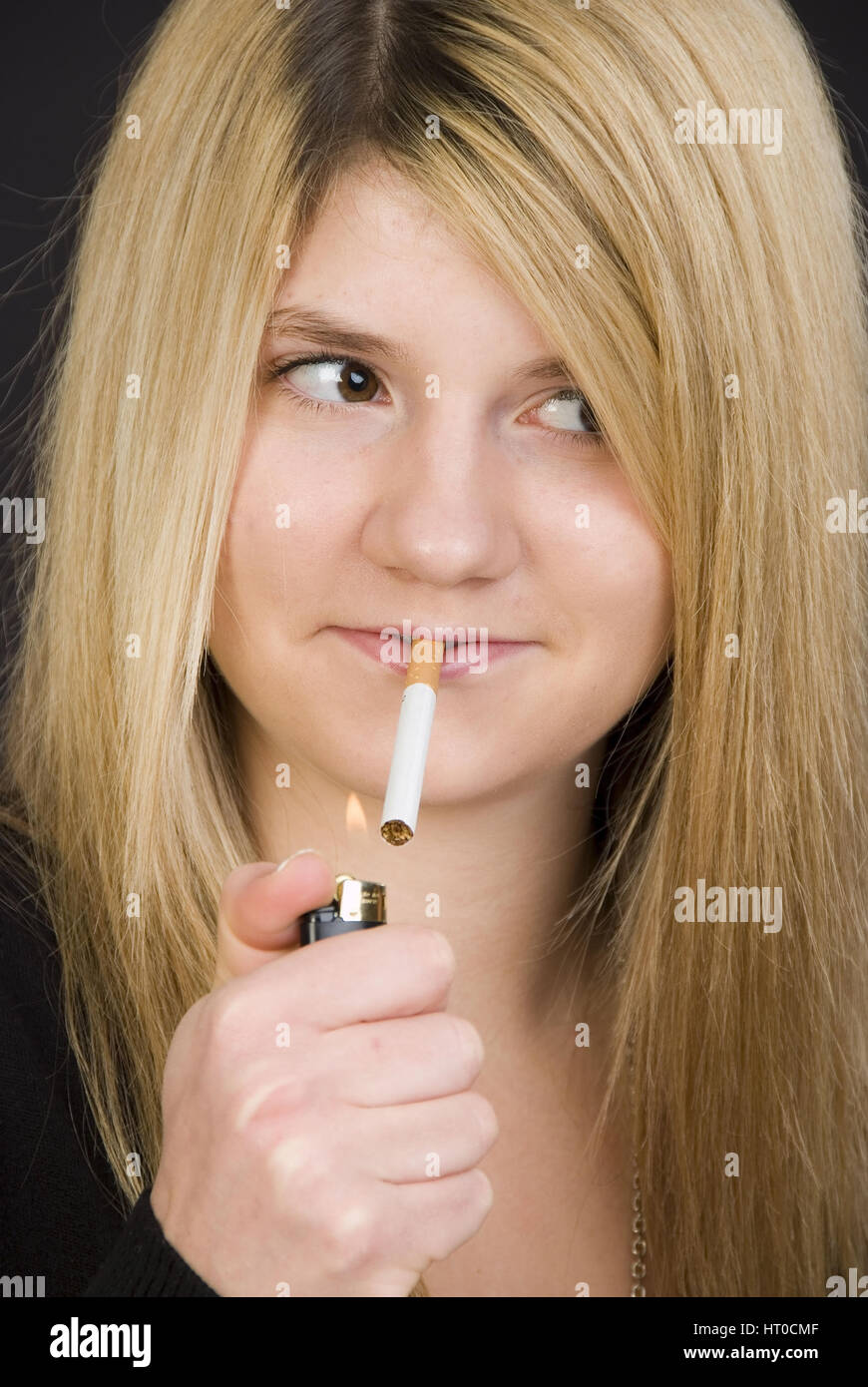 Jugendliches M‰dchen z'ndet sich heimlich eine Zigarette un - Teenager fuma una cigaret Foto Stock