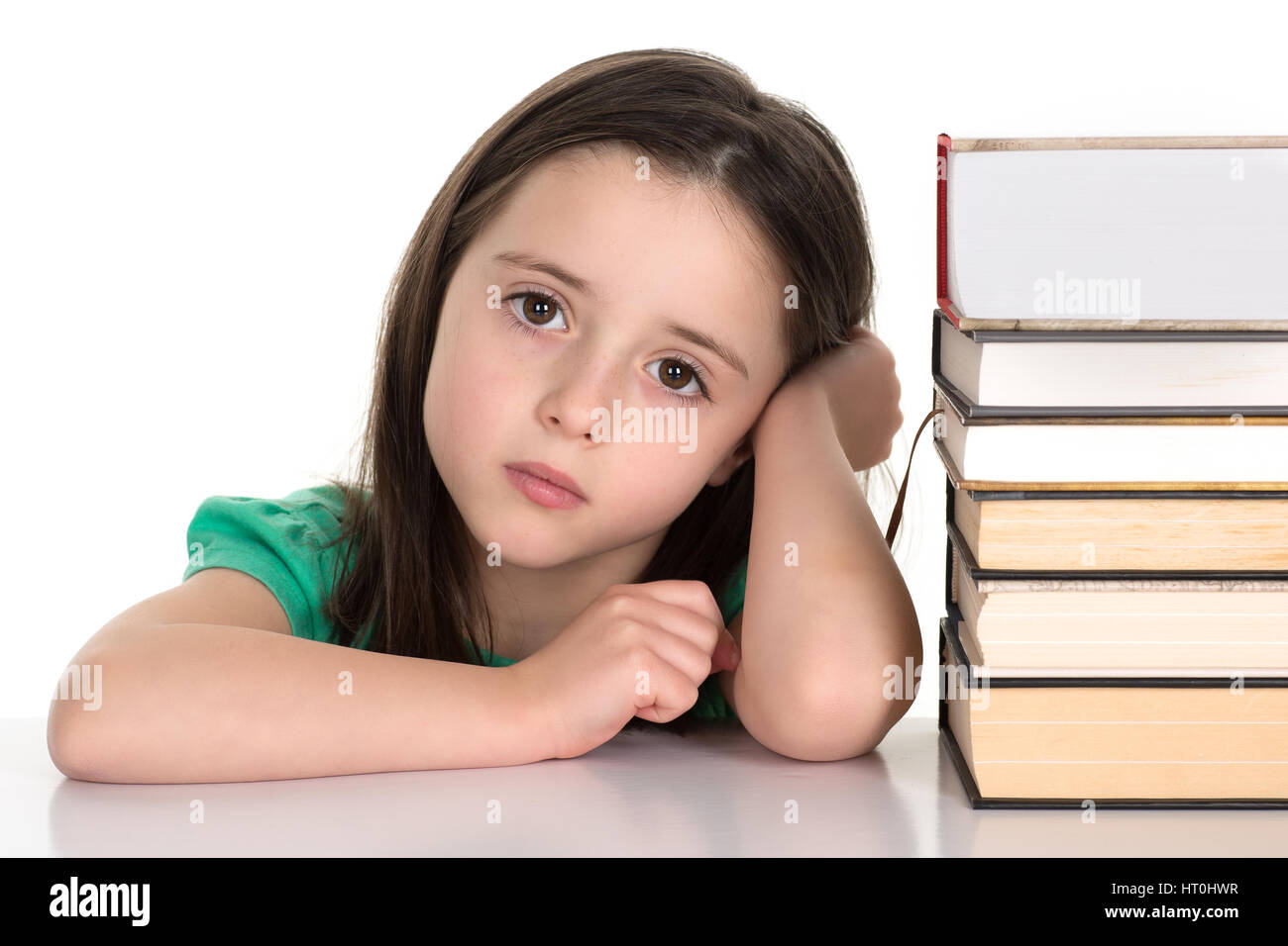 Studente o una scuola ragazza seduta dalla pila di libri sempre pronto a fare un dovere. Isolato su uno sfondo bianco. Foto Stock