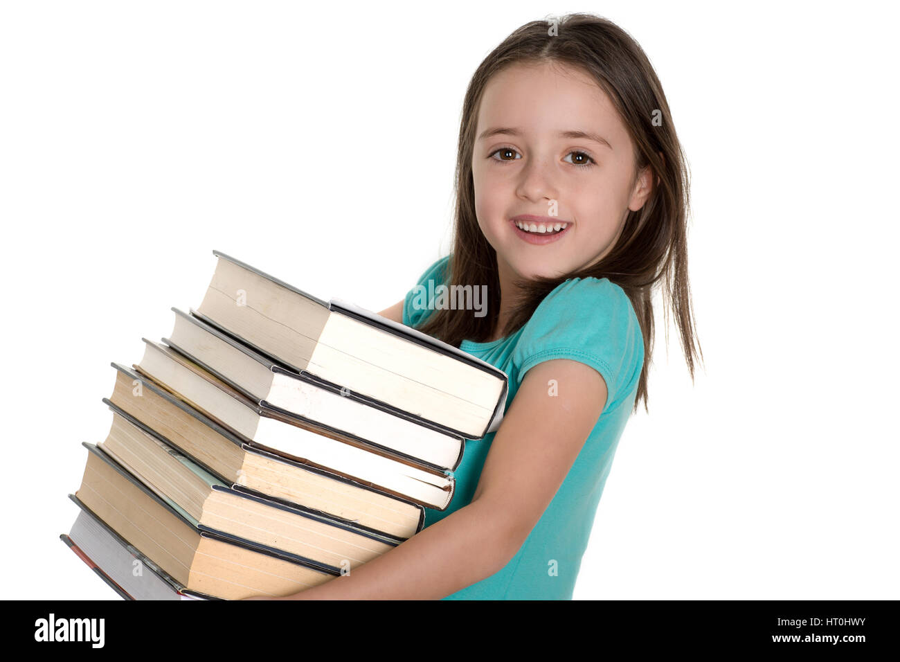 Scuola ragazza sorridente e portante pila di libri pesanti. Isolato su uno sfondo bianco. Foto Stock