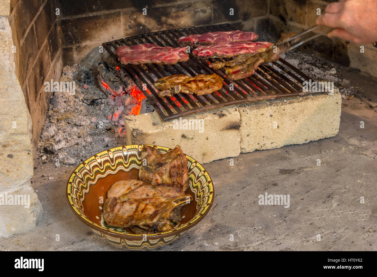 La tostatura carni fresche nel camino e ciotola con bistecca . Fare  barbecue Foto stock - Alamy