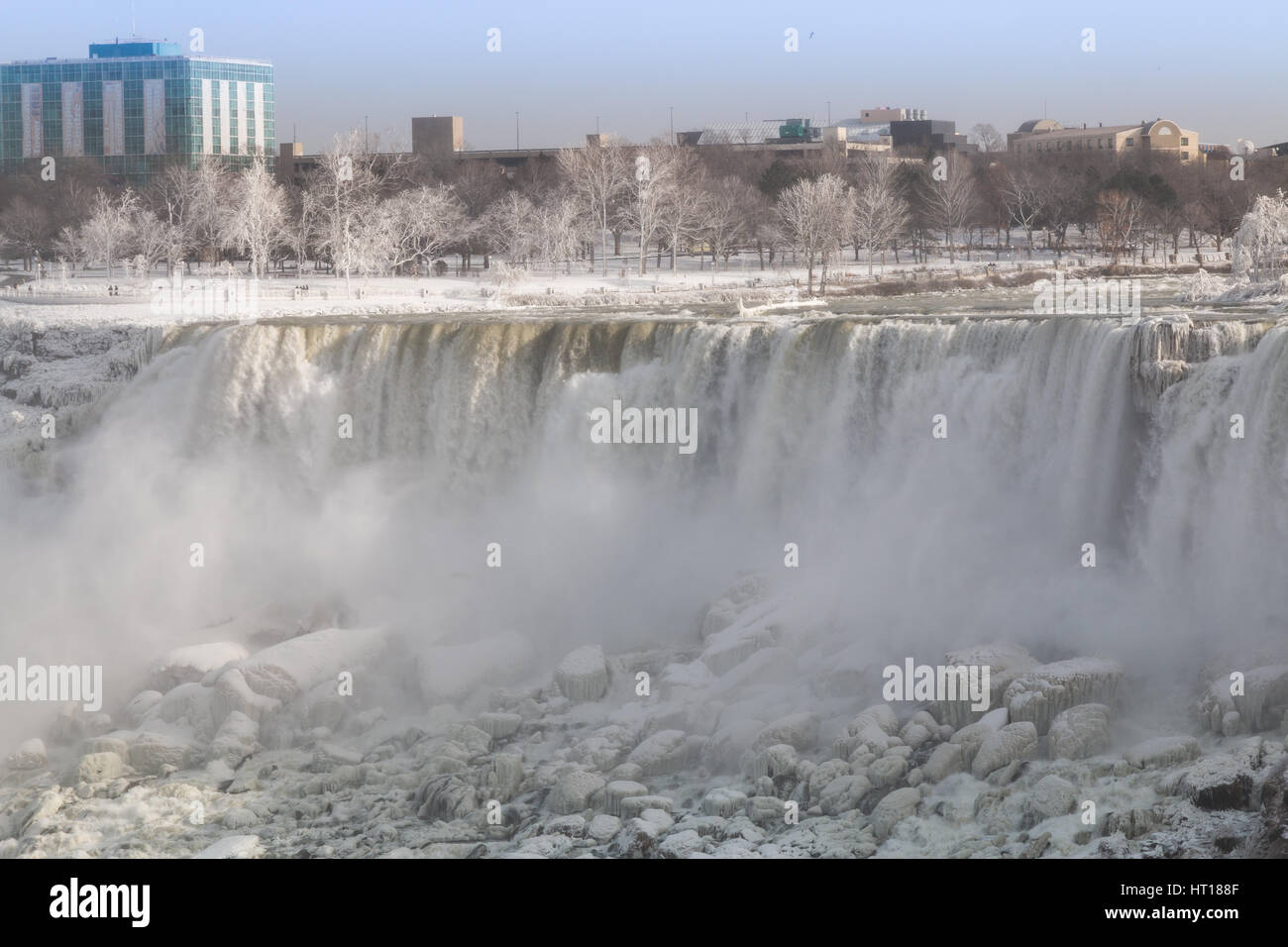 Cascate del Niagara sul il canadese di frontiera degli Stati Uniti d'inverno. Coulds di spray congelato nell'aria. Foto Stock