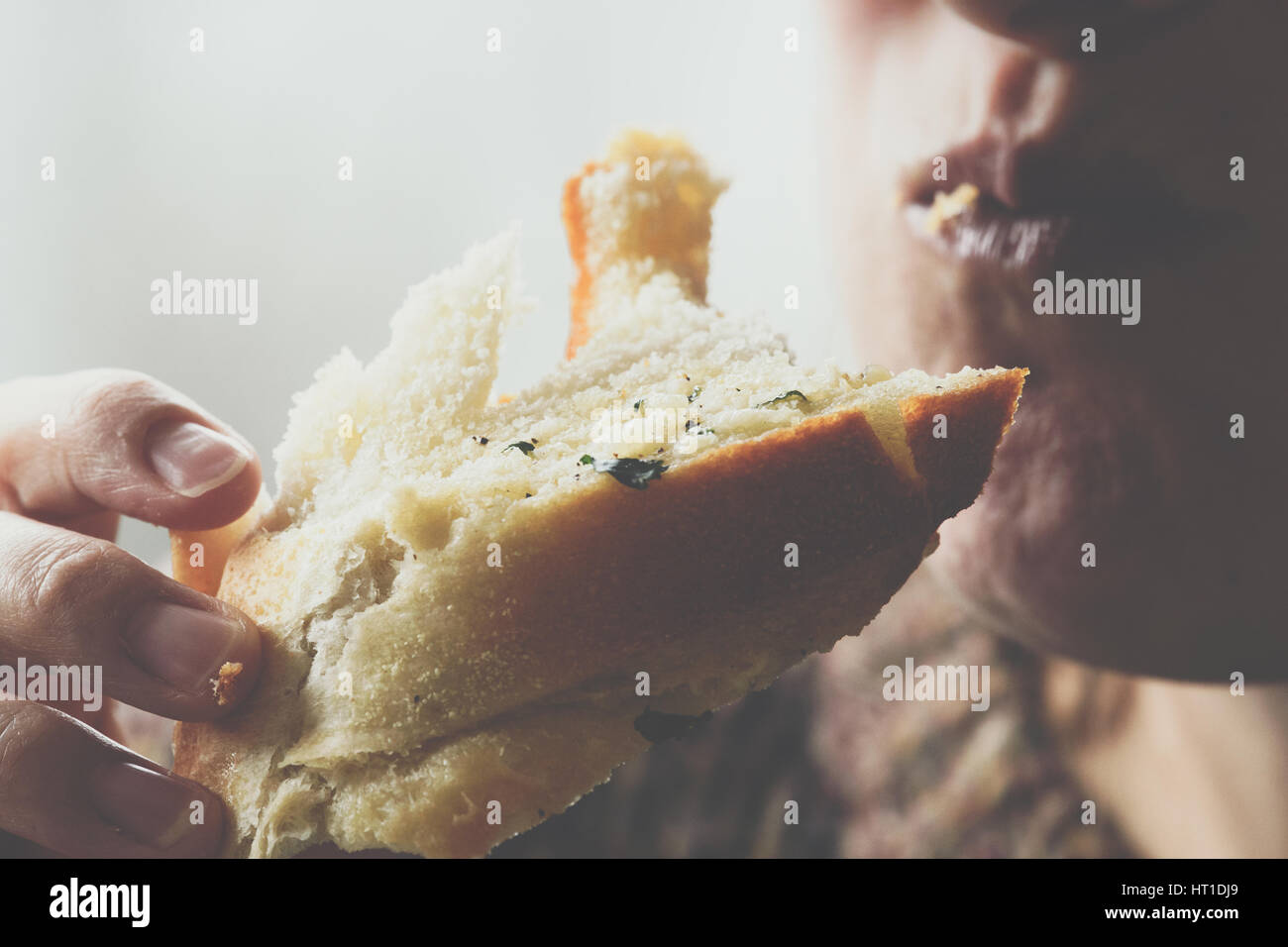 Primo piano della donna mangiare aglio pane Foto Stock