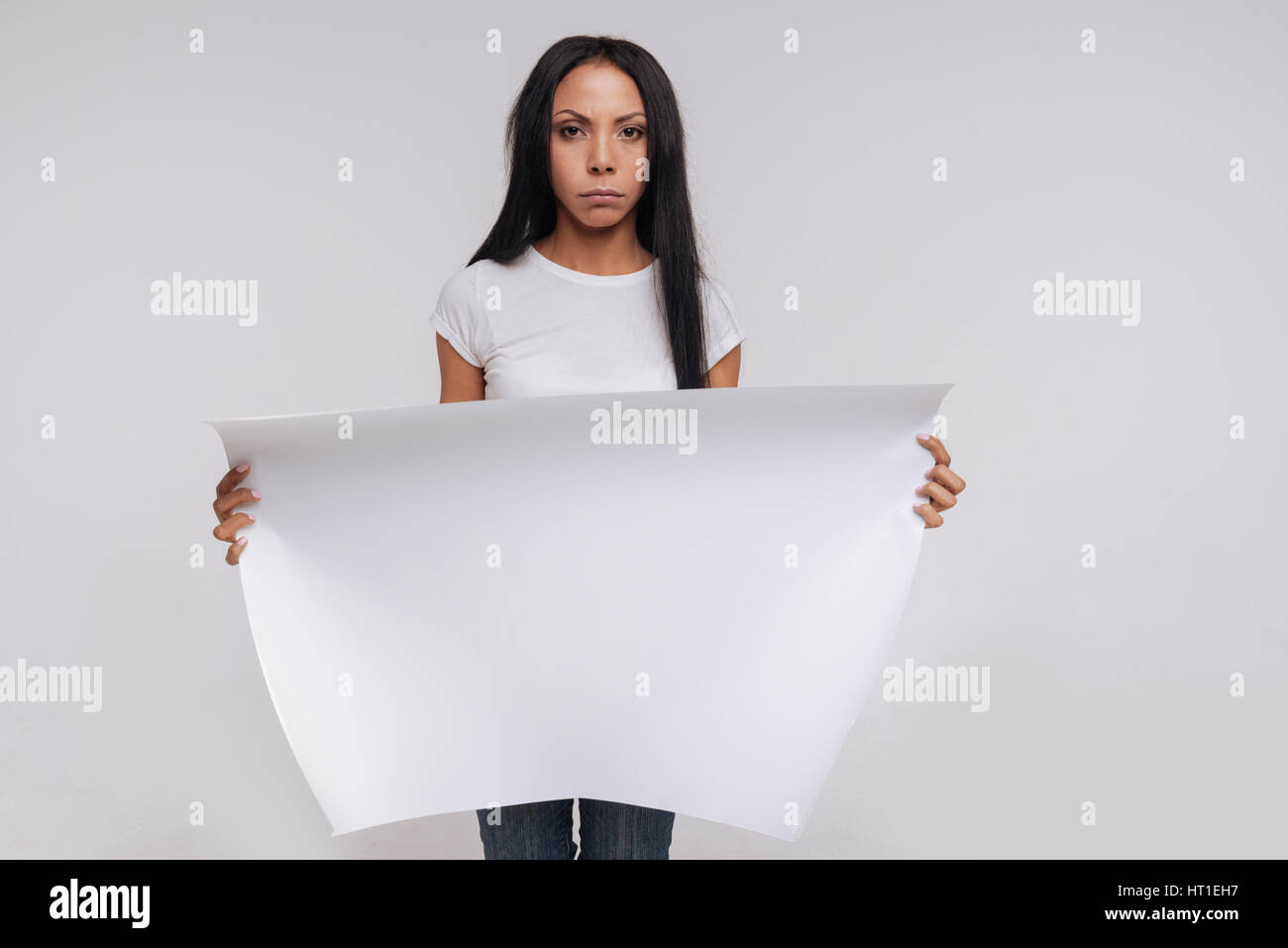 Si deve sapere a proposito di questo. Grazioso potente donna gorgeous tenendo in mano un grande bianco cantare mentre si lavora su una campagna sociale e posare per un photographe Foto Stock