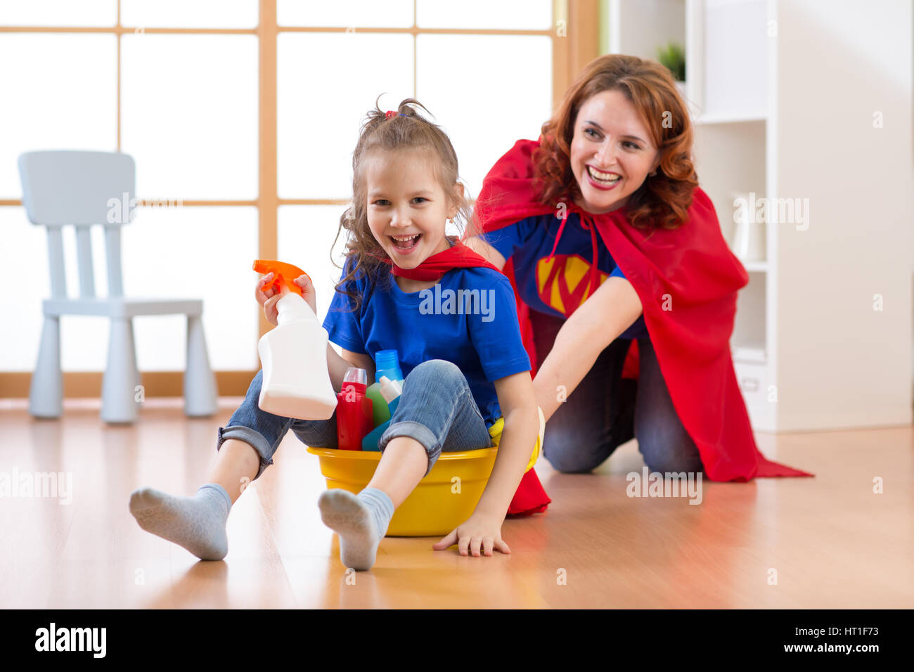 Preschooler bambino ragazza e sua madre la riproduzione mentre fare pulizia in casa Foto Stock