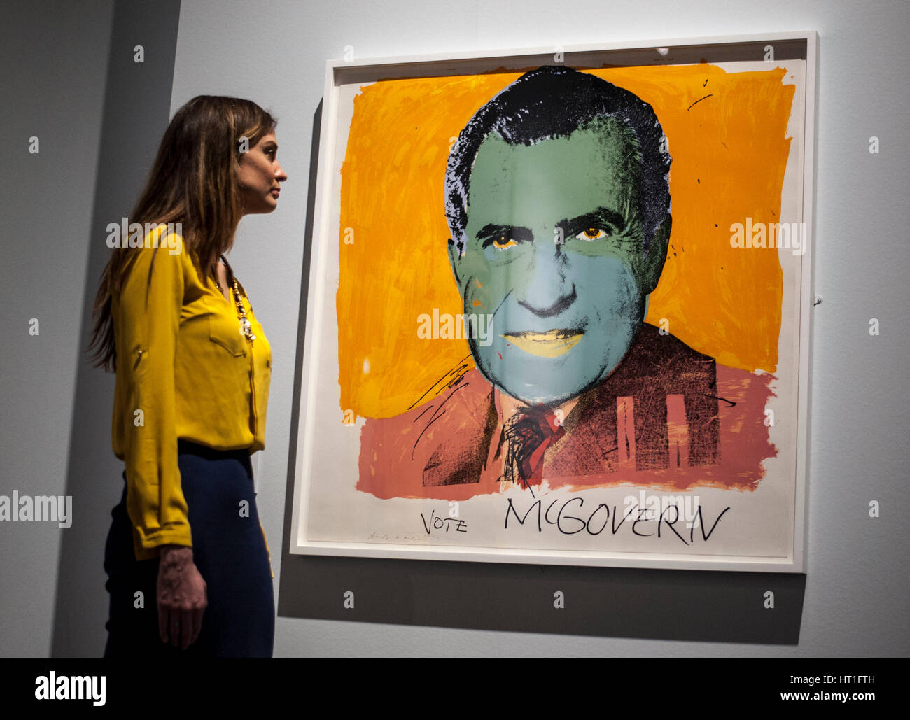 Un membro dello staff osserva Vota McGovern 1972 di Andy Warhol, una delle 200 stampe americane dagli anni '60 ai giorni nostri svelate al British Museum di Londra, durante una telefonata in vista dell'American Dream: Pop al lancio della mostra il 9 marzo Foto Stock