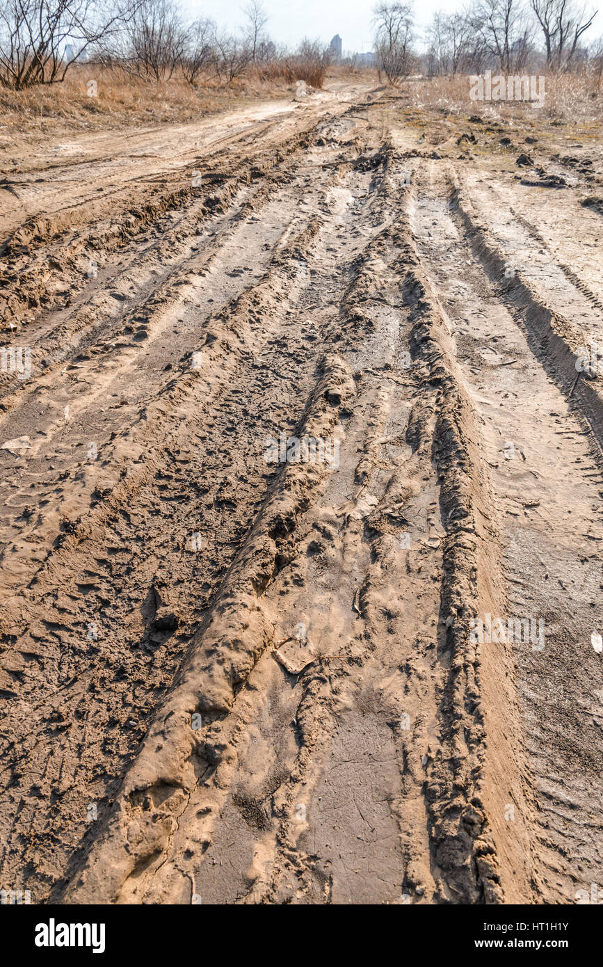 Profonde tracce di pneumatici sulla strada coperta da bagnato sabbia fangose Foto Stock