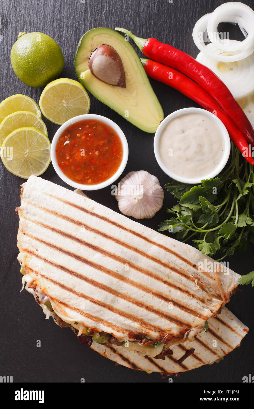 Cibo messicano: Quesadillas con carne di manzo, fagioli, avocado e formaggio vicino sul tavolo. vista verticale da sopra Foto Stock