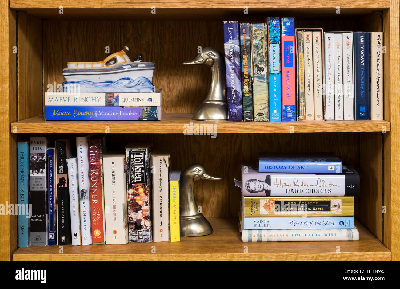 Libri su uno scaffale con anatra in ottone bookends. Foto Stock