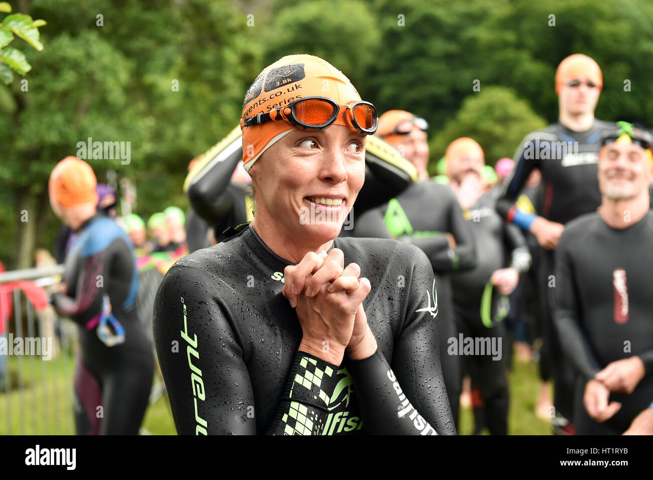 Una donna guarda nervoso prima di lei nuotare a un Open Water Swimming evento lago Ullswater, Cumbria Regno Unito Foto Stock