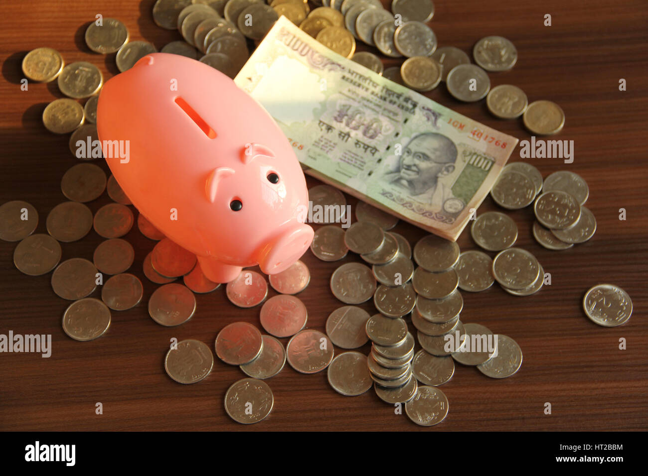 Risparmio di denaro per comprare una casa o casa. Salvadanaio con banconote e monete Foto Stock