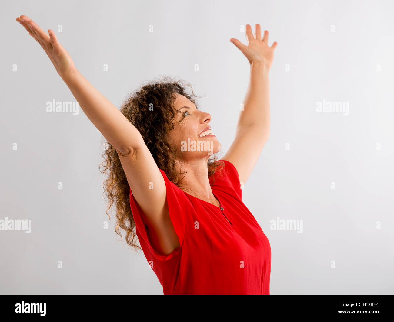 Ritratto di un felice di mezza età brunette con le braccia in alto Foto Stock