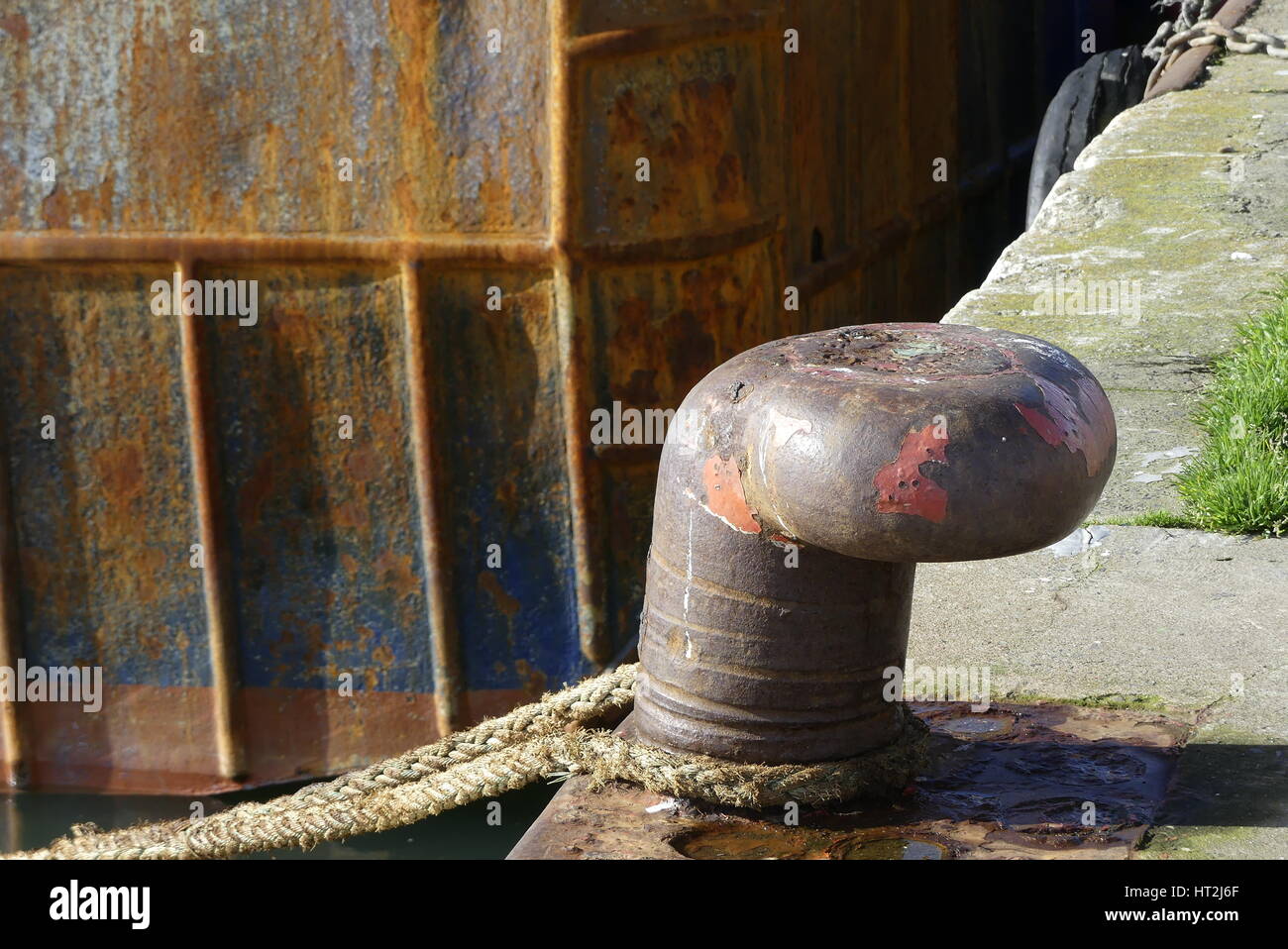 Rusty bollard e cima di ormeggio nel porto di pesca di Lorient, Bretagna Francia. Foto Stock