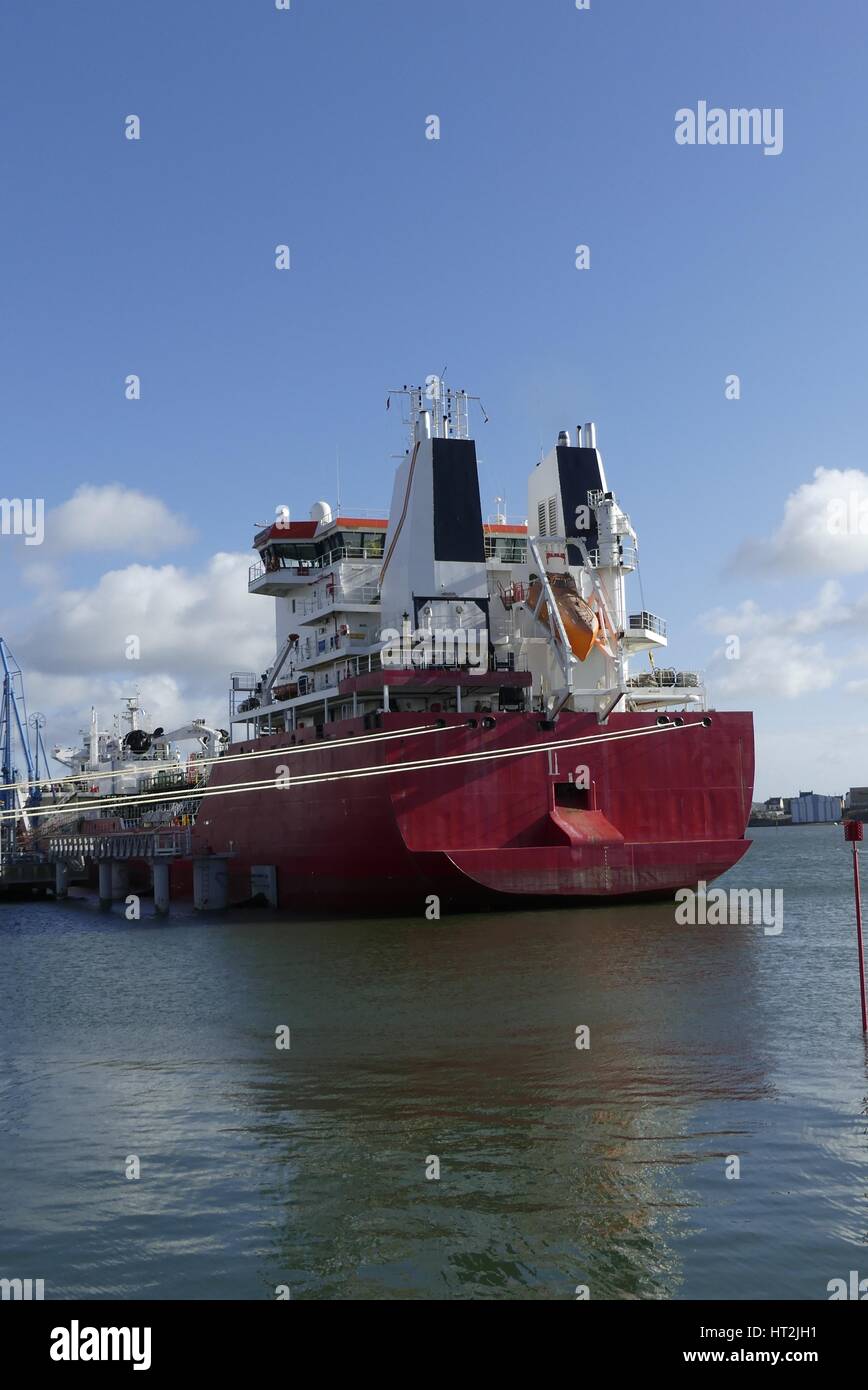 Prodotti scarica petroliera al terminale petrolifero di Lorient, Francia, con scafo di colore rosso e bianco imbuto in una giornata di sole. Foto Stock