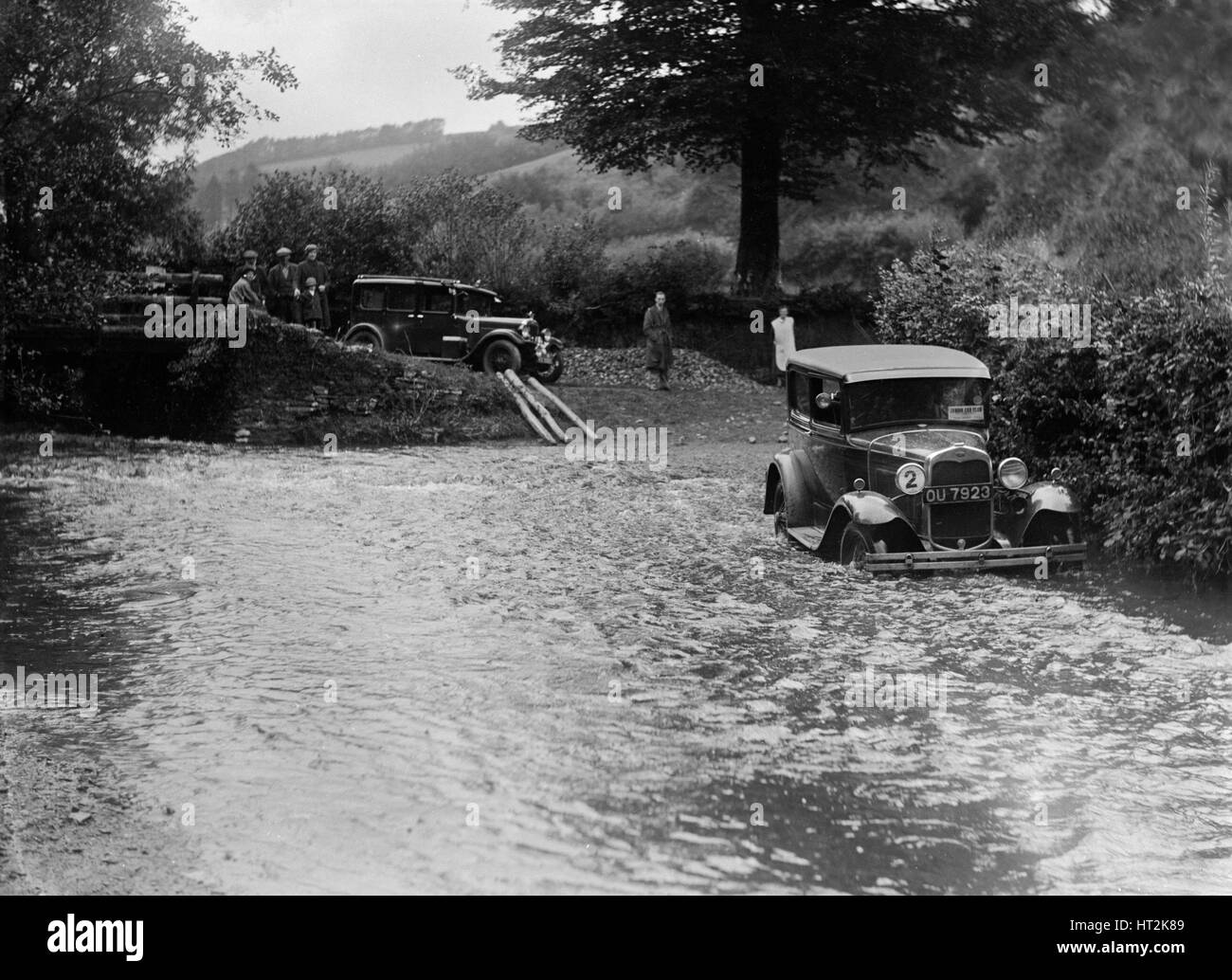 Ford modello A del JW Robbins guadare il fiume Exe al Yealscombe, Devon, JCC Lynton Trial, 1932. Artista: Bill Brunell. Foto Stock