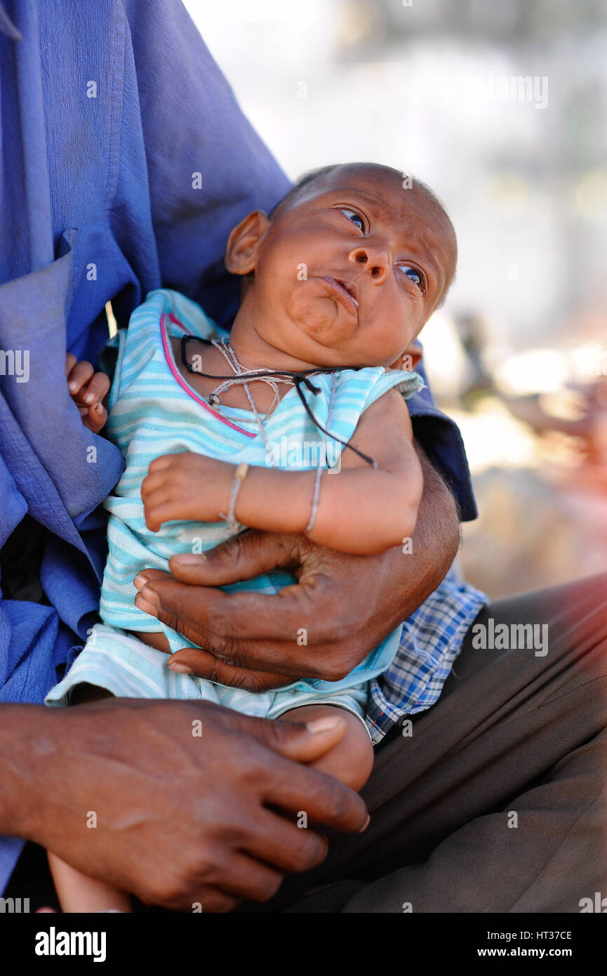 Il babe in armi, indossando numerosi thread indù Foto Stock