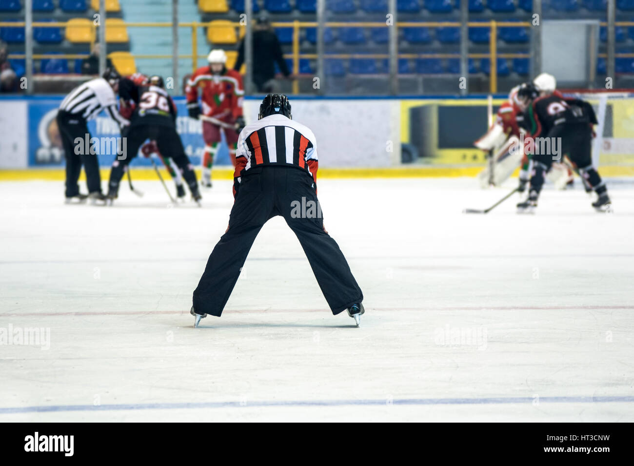 Vista posteriore sulla arbitro controlla la partita di hockey. Foto Stock
