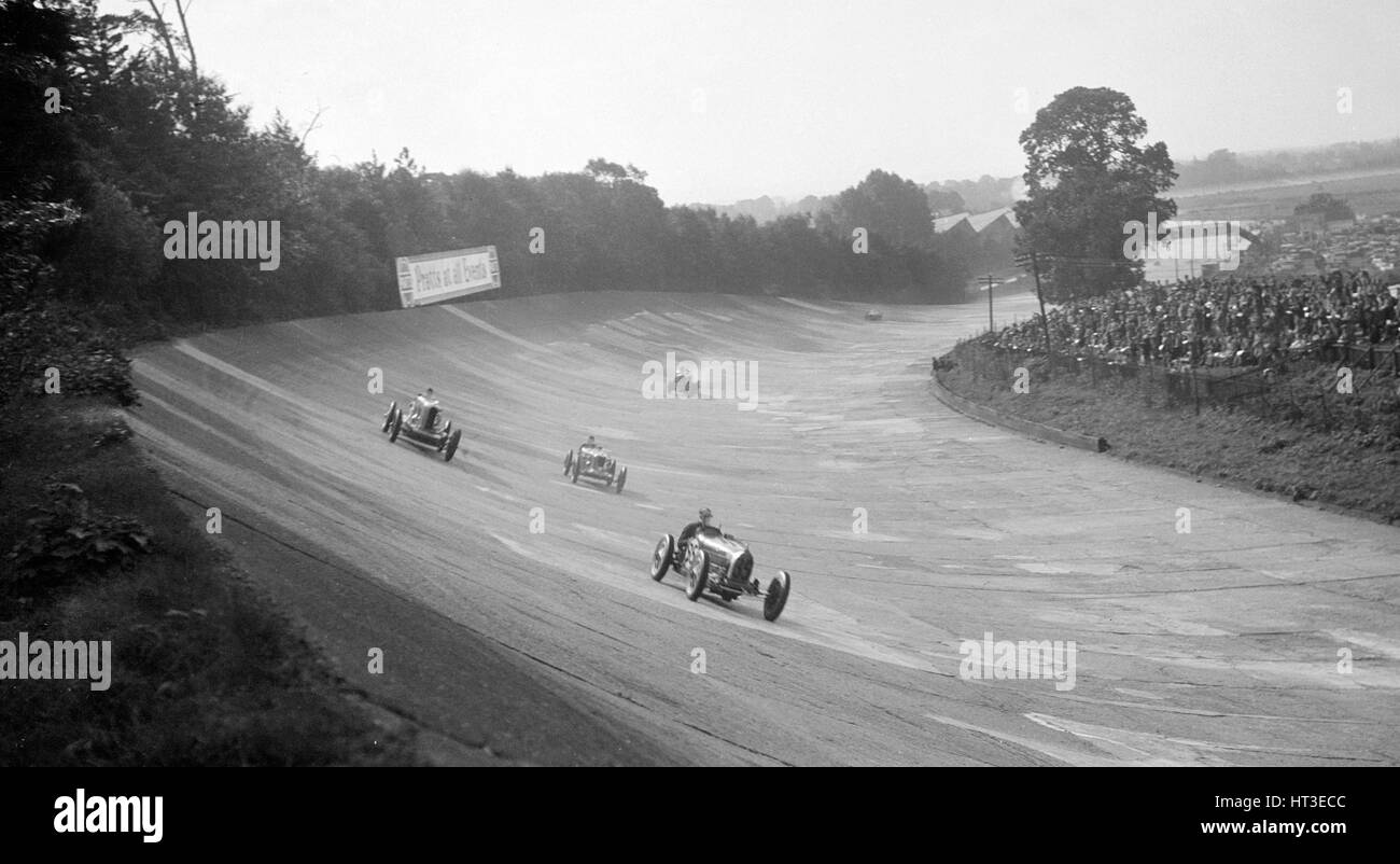 Bugatti 54 conduce una Talbot 90 sul settore bancario a Brooklands, 1930s. Artista: Bill Brunell. Foto Stock