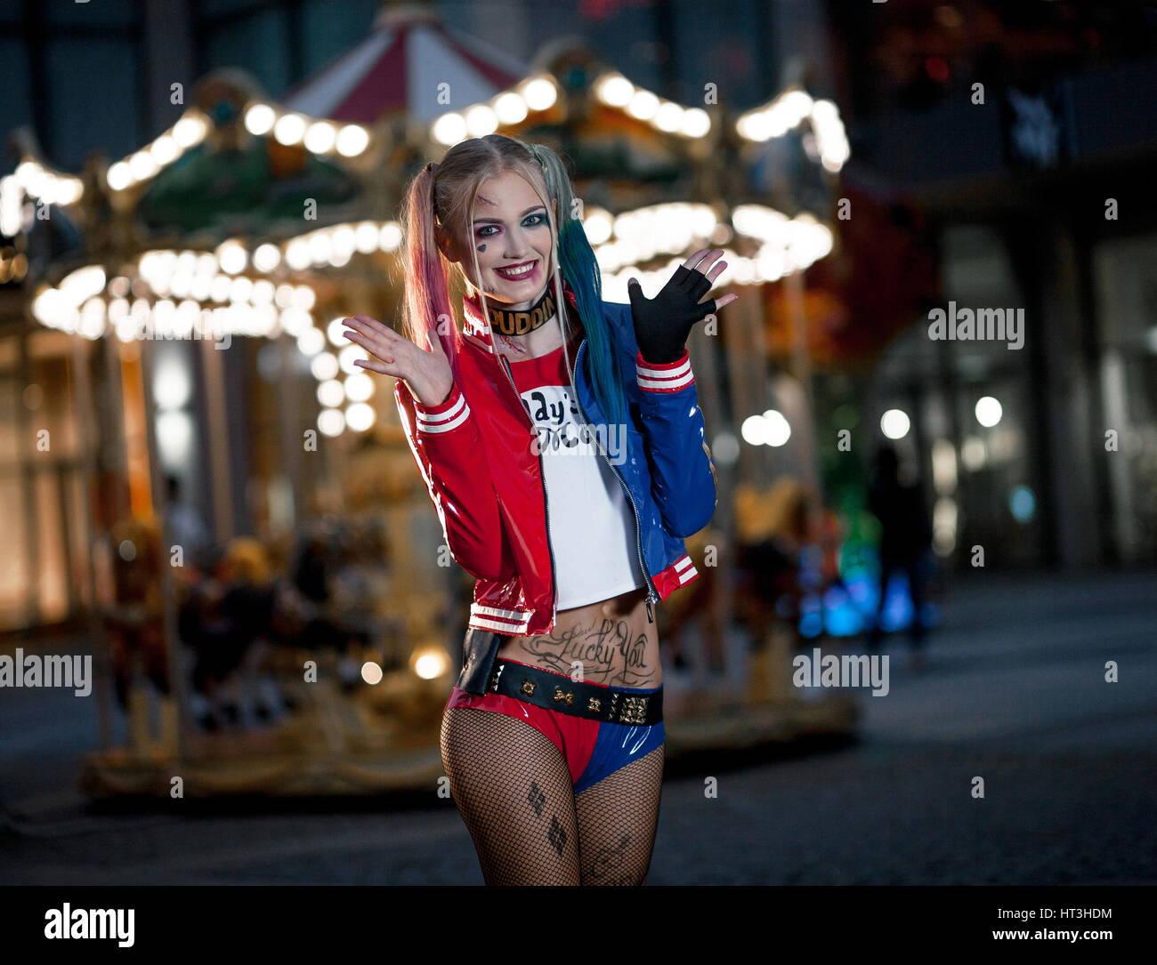 Sorridente ragazza in costume Harley Quinn su sfondo di notte le luci della  città. Cosplay Foto stock - Alamy