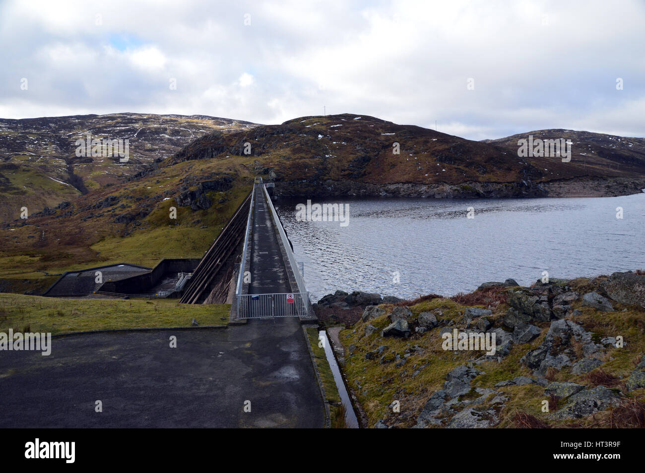 La passerella sul Loch Lednock parete Dam sulla strada per la montagna scozzese Corbett Creag Uchdag in Glen Lednock, Highlands scozzesi, Scotland, Regno Unito. Foto Stock