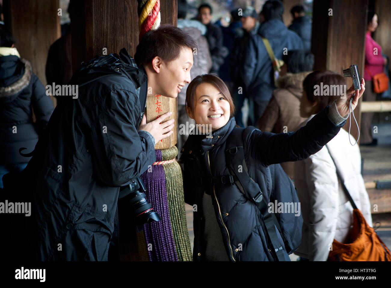 I turisti tenendo selfies presso un santuario shintoista, Kyoto, Giappone Foto Stock