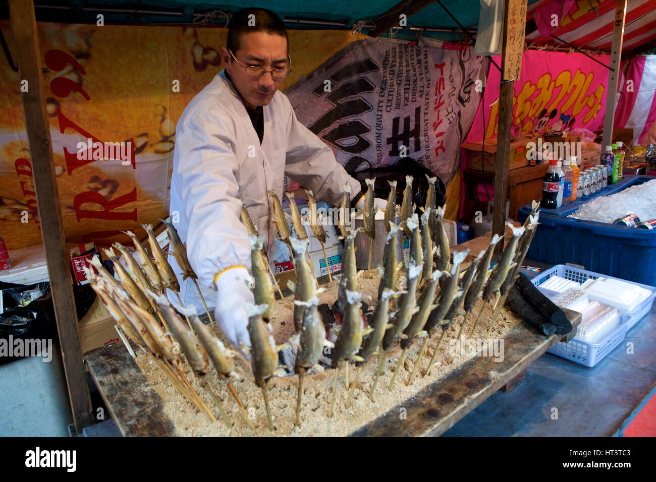 Venditore a vendere pesce essiccati su un bastone, Kyoto in Giappone Foto Stock