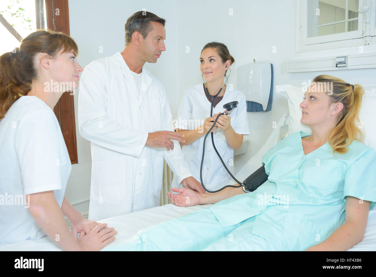 Assistenza infermieristica apprendimento dello studente a prendere la pressione sanguigna Foto Stock