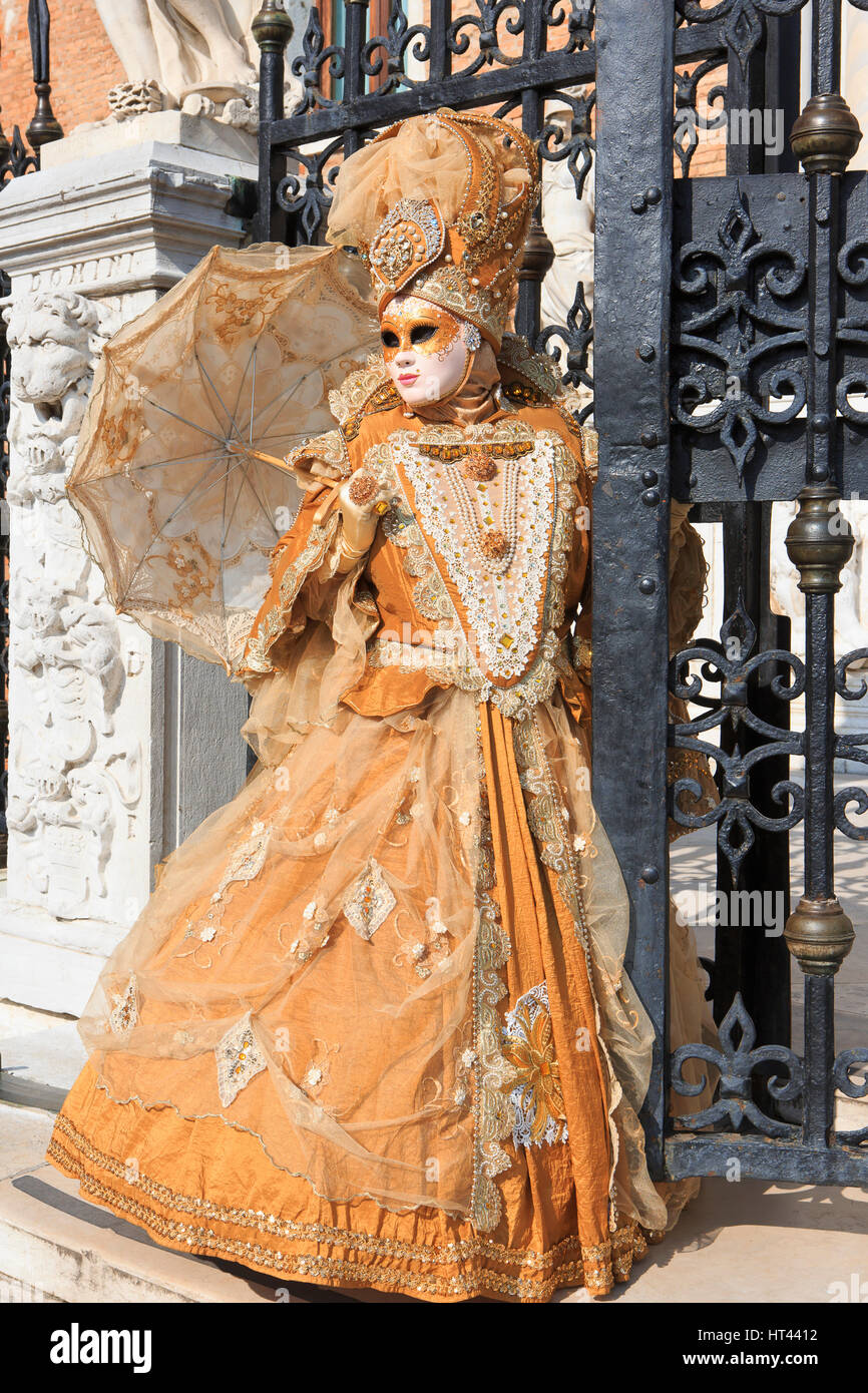 Una donna mascherata con ombrello all'ingresso dell'Arsenale di Venezia durante il Carnevale di Venezia, Italia Foto Stock