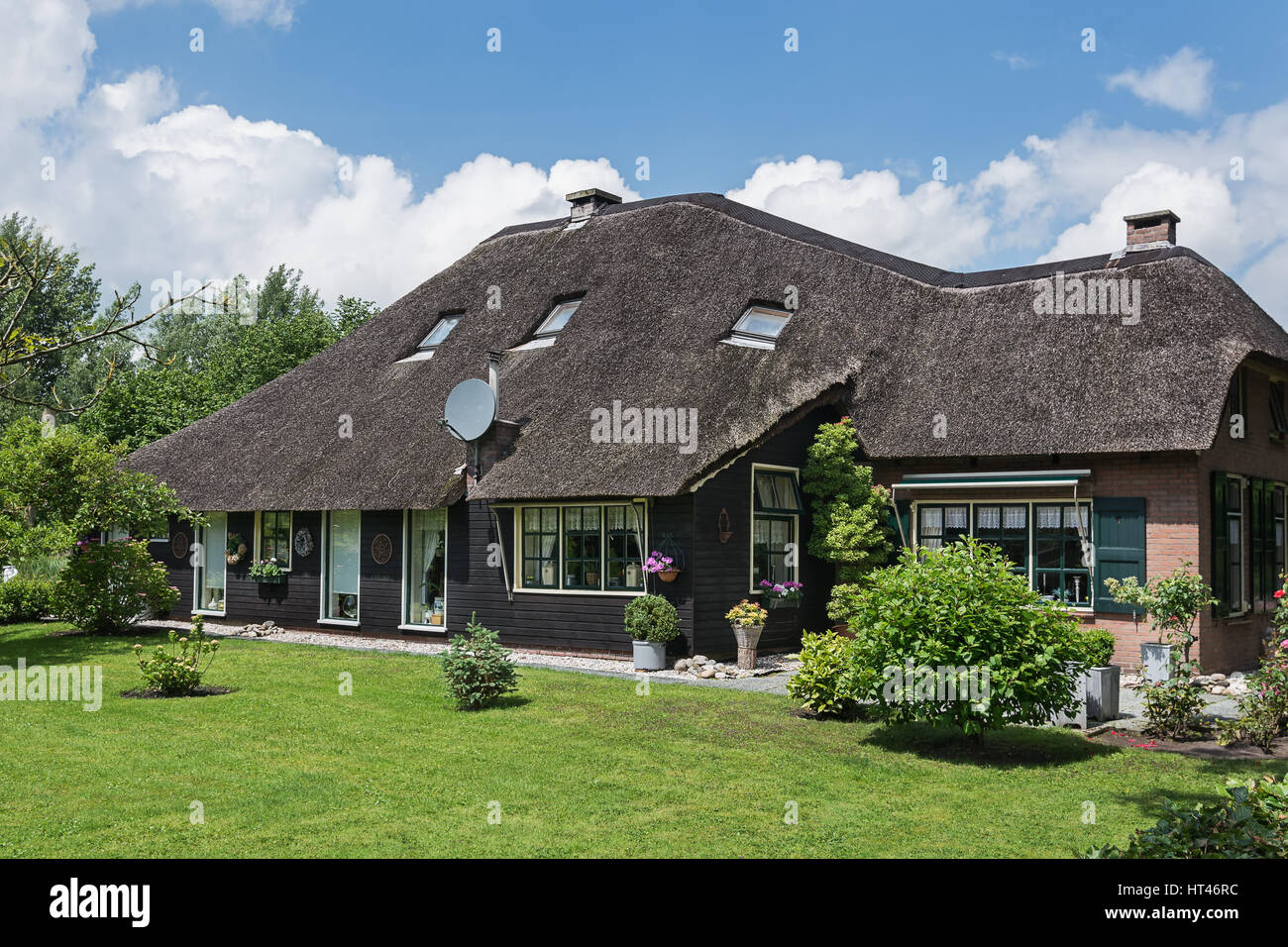 La facciata della vecchia casa residenziale con un tetto di paglia in un piccolo villaggio olandese di Giethoorn. Foto Stock