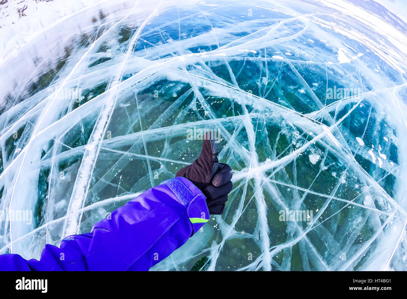 A braccetto con il pollice in su contro incrinato blue ice di Baikal. Foto Stock