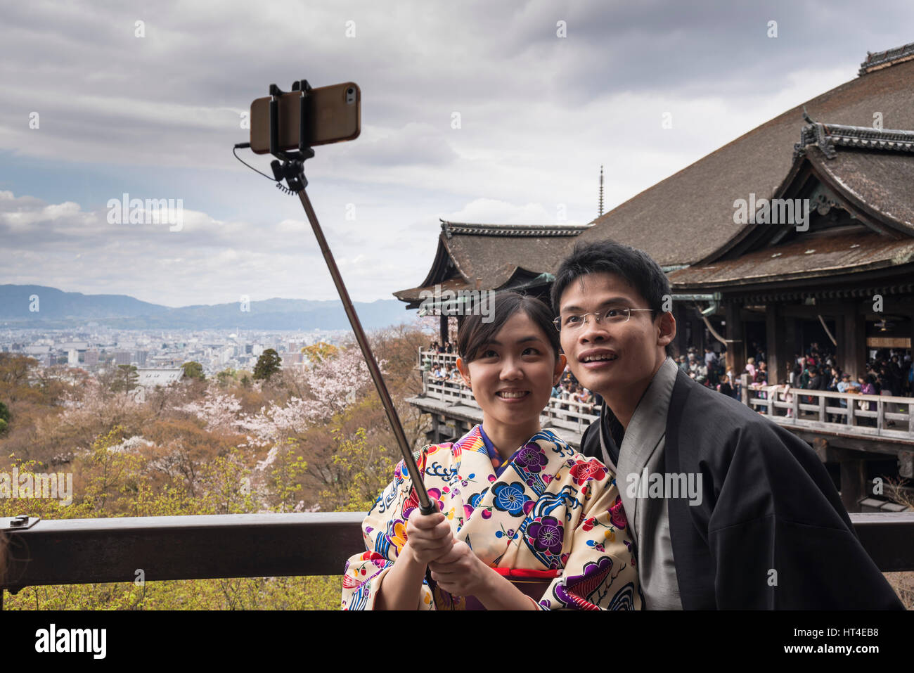 Una giovane coppia di turisti in un kimono, il costume tradizionale giapponese, tenendo selfie con selfie bastone di Kiyomizu dera, tempio buddista a Kyoto, Giappone Foto Stock