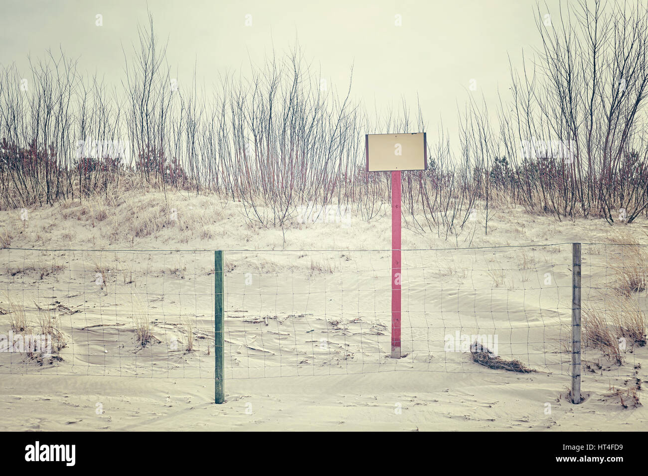 Segno sulla duna di spiaggia dietro un recinto, spazio per testo, dai toni di colore dell'immagine. Foto Stock