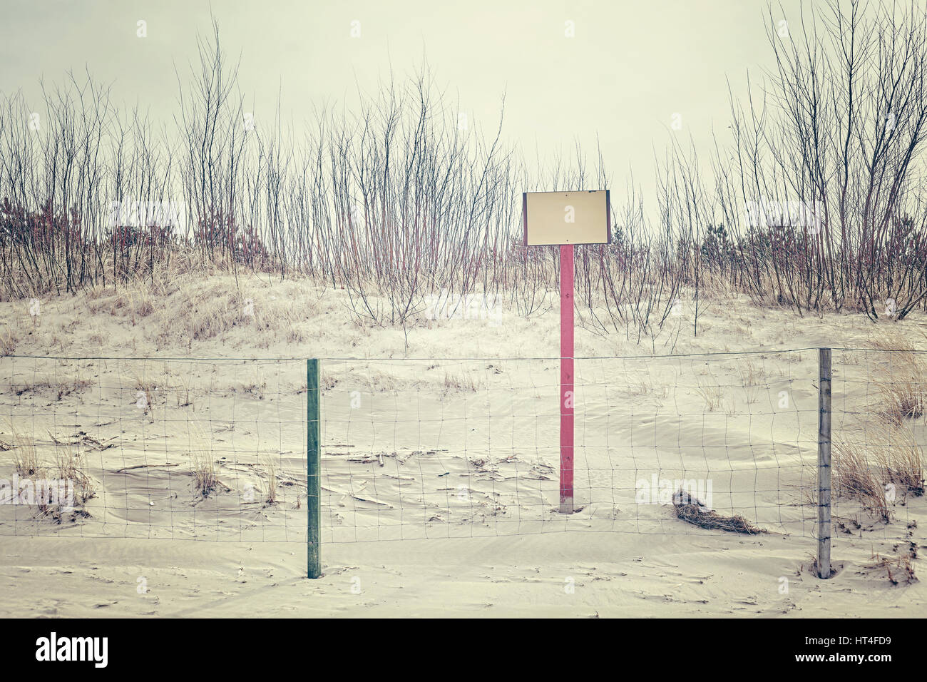 Segno sulla duna di spiaggia dietro un recinto, spazio per testo, dai toni di colore dell'immagine. Foto Stock