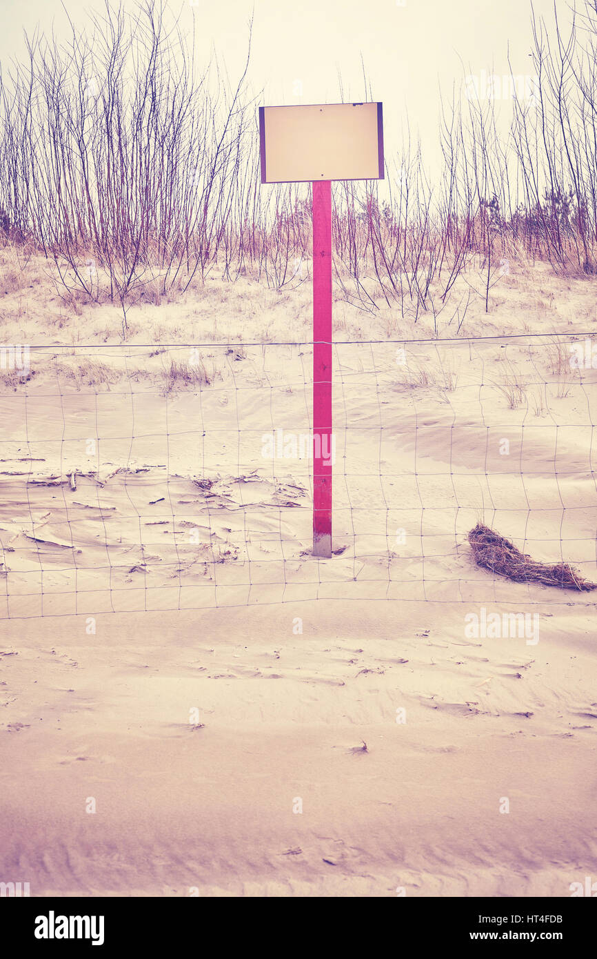 Segno sulla duna di spiaggia dietro un recinto, spazio per testo, dai toni di colore foto, messa a fuoco selettiva. Foto Stock
