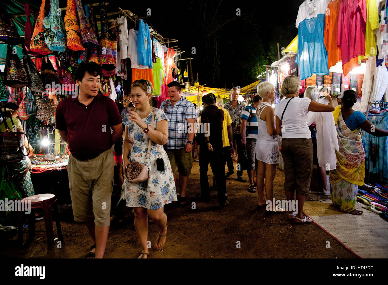 I visitatori del sabato notte di mercato in Arpora, India. Il mercato è aperto ogni sabato durante la stagione turistica. Vi è una grande selezione di capodanno Foto Stock