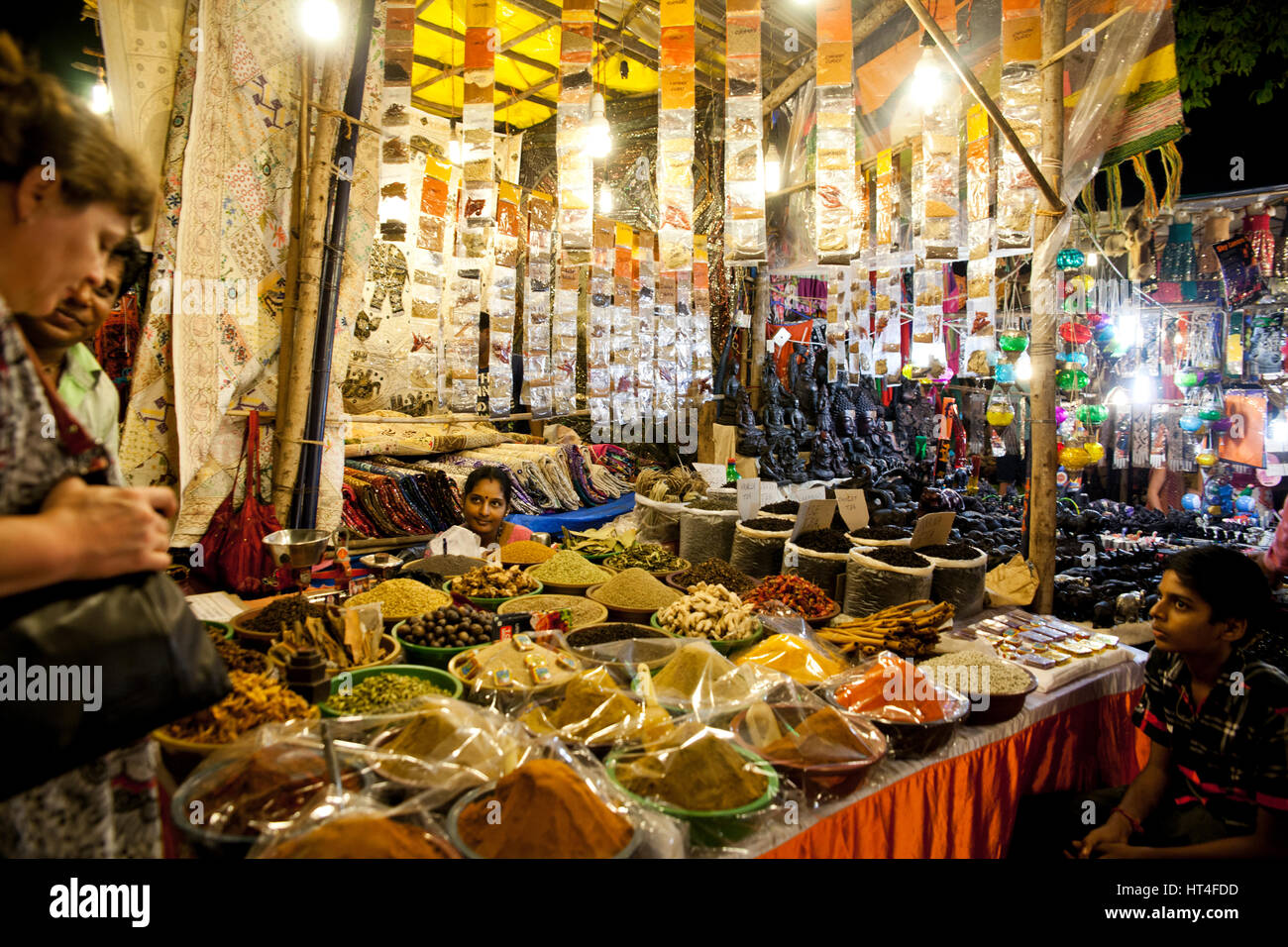 Donna vendita di diversi tipi di spezie al sabato notte di mercato in Arpora, India. Il mercato è aperto ogni sabato durante la stagione turistica. Il Foto Stock