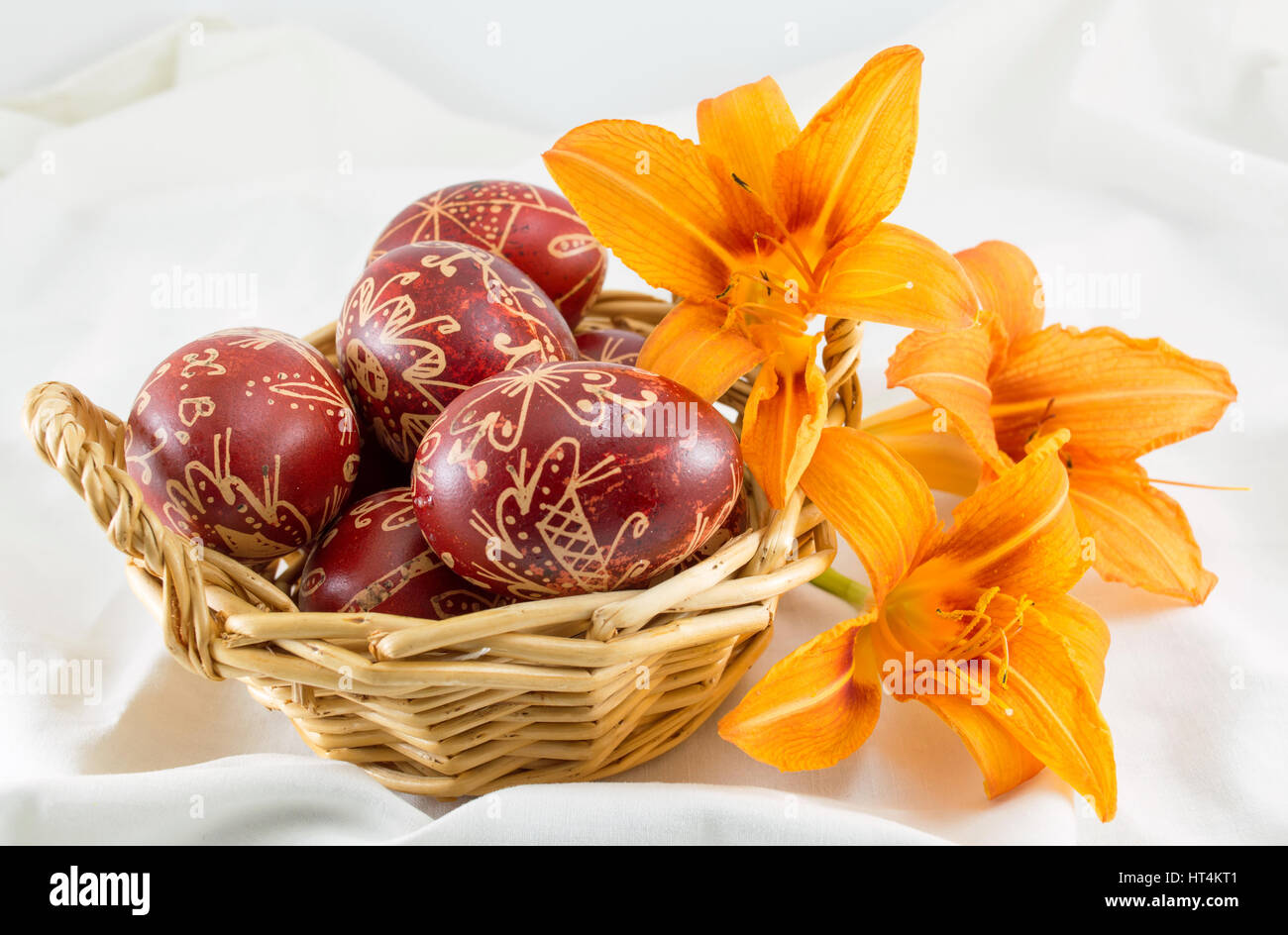 Cera dipinte di rosso le uova di Pasqua in un recipiente di vimini Foto Stock