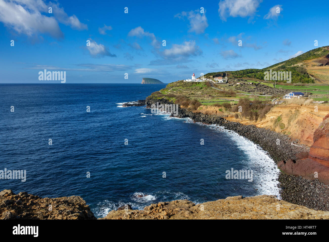 Ampio angolo di visione di costa vulcanica, faro e goat island in Terceira, Portogallo Foto Stock