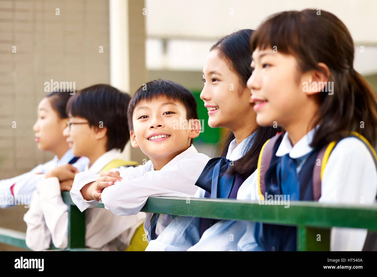 Gruppo di asian bambini di scuola elementare con un ragazzo che guarda in telecamera sorridente. Foto Stock