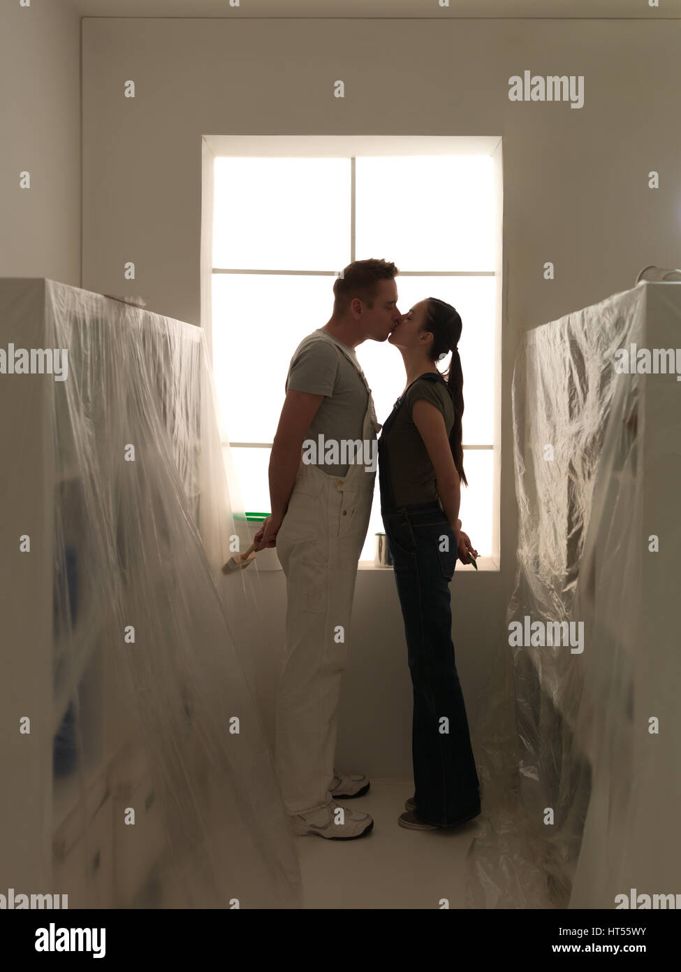 Coppia felice kissing nella loro nuova casa tenetevi pronti a rifare il DIY Foto Stock