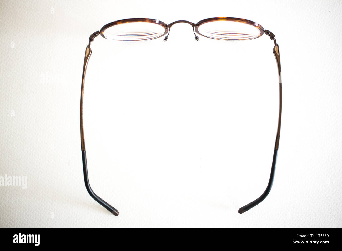 Occhiali Vintage sulla tela bianca su sfondo di carta vicino. Foto Stock